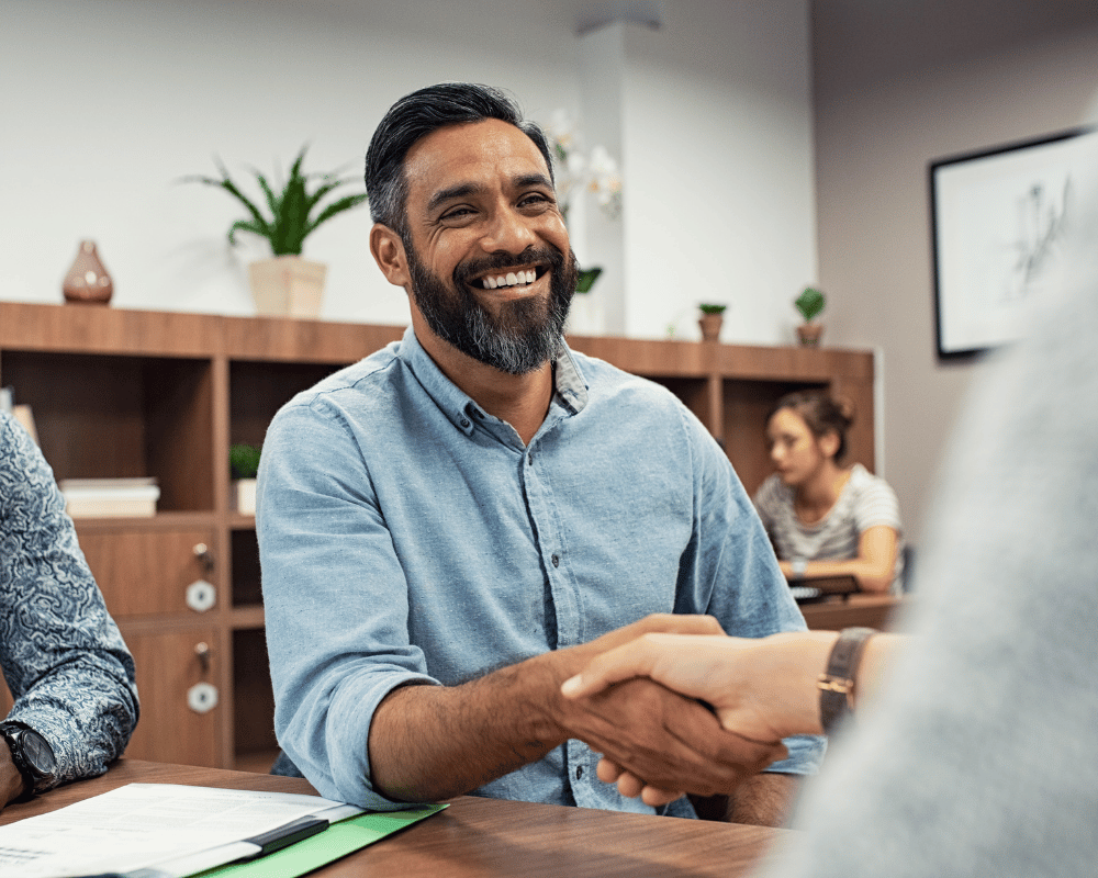 Business owner smiling while shaking hands after a successful partnership